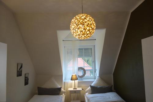 a room with two beds and a chandelier and a window at Hotel & Restaurant Venner Moor in Senden
