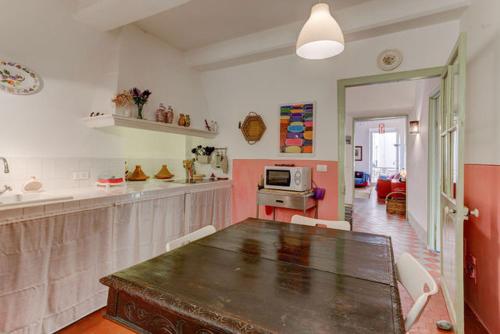 una sala da pranzo con tavolo e una cucina di Les Fresques a Mentone