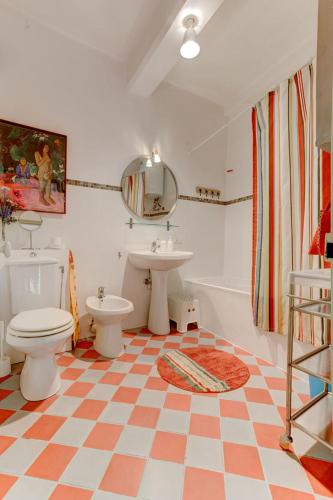 La salle de bains est pourvue d'un sol en damier, de toilettes et d'un lavabo. dans l'établissement Les Fresques, à Menton
