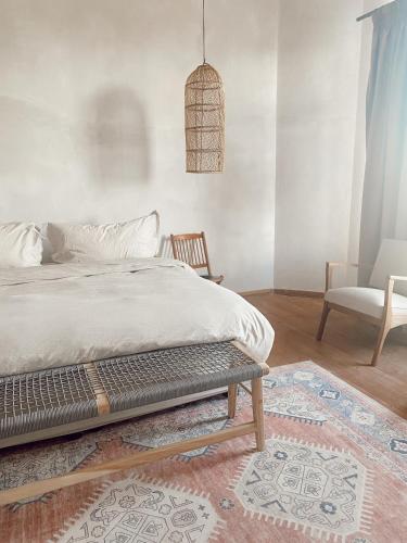 a bedroom with a bed and a chair and a rug at Britskraal Guest Farm in Strydenburg