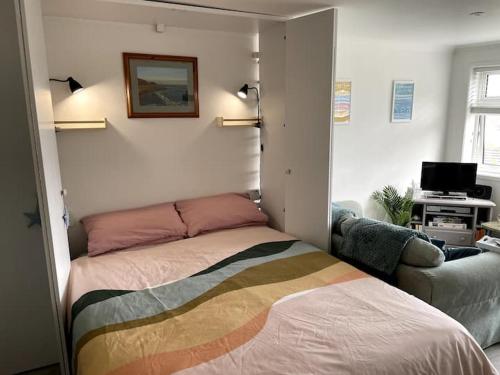 a bedroom with a bed and a couch at Self-catering studio in beautiful Charmouth in Charmouth