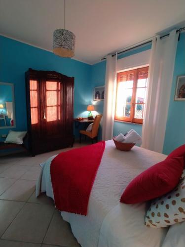a bedroom with a large bed with red and white pillows at Il Sentiero B&Bìo in SantʼAntìoco