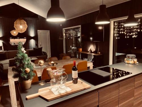 a kitchen with a table with a bottle of wine on a counter at Hytte Trysil SPA in Trysil