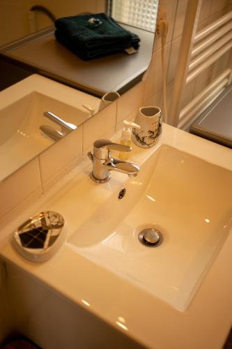 - un lavabo avec deux tasses dans l'établissement CHARMANT STUDIO☆NETFLIX☆CANAL+☆CANAL SAT☆PARKING☆, à Ramonville-Saint-Agne