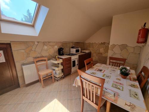 a kitchen with a table and chairs in a room at Abigél 2 Vendégház in Miskolctapolca