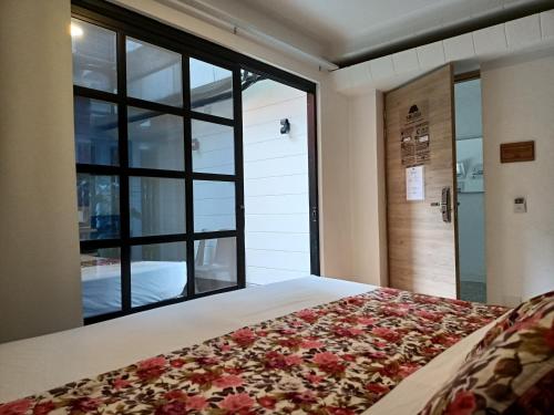 1 dormitorio con cama y ventana grande en Hotel Poma Rosa en Medellín