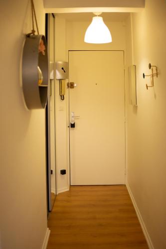 un couloir avec une porte et une personne debout devant celle-ci dans l'établissement CHARMANT STUDIO☆NETFLIX☆CANAL+☆CANAL SAT☆PARKING☆, à Ramonville-Saint-Agne