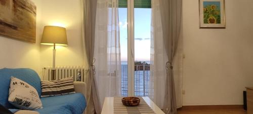 a living room with a blue couch and a large window at Mediterraneo Travel in Gela