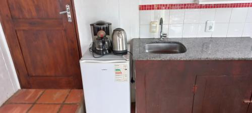 una pequeña cocina con fregadero y nevera. en Ancora en Punta del Diablo