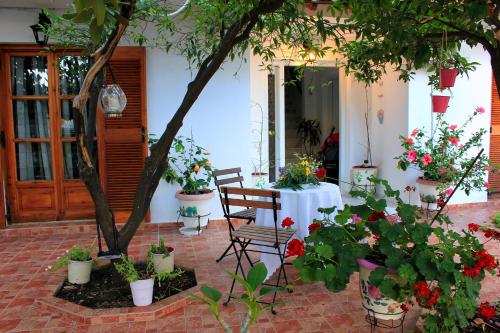 a table and chairs in a courtyard with flowers at Vaya Zorba Studios in Skiathos Town