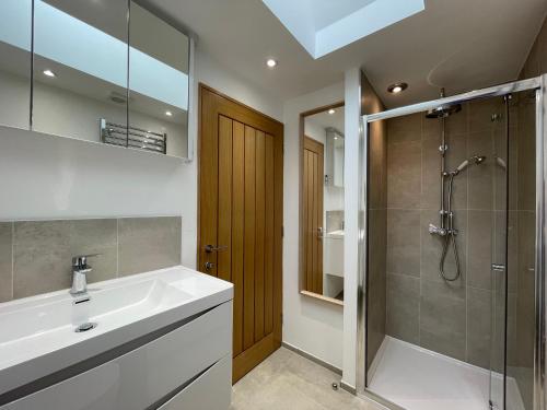 La salle de bains est pourvue d'un lavabo et d'une douche. dans l'établissement Whitley Old Garage, à Whitley