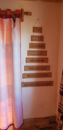 a christmas tree sign on the wall of a room at La Quimera a pasos de la playa in Atlántida