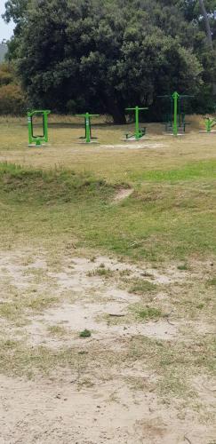 an empty park with green benches in a field at La Quimera a pasos de la playa in Atlántida