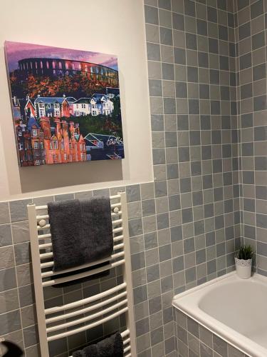 a bathroom with a painting on the wall and a sink at Heart of George street / Oban / Argyll in Oban