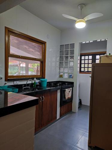 a kitchen with a sink and a stove and a window at Linda casa de condomínio em Boiçucanga in São Sebastião