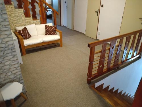 a hallway with a couch and a stair case at Apartmán U Čechů in Albrechtice v Jizerských horách