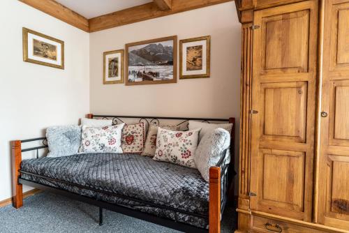 a couch in a room with a wooden door at Górski klimat Apartament in Zakopane