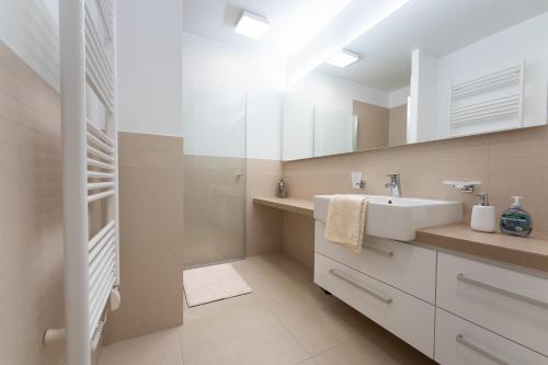 a bathroom with a sink and a mirror at Apartments Feral Portorož in Portorož