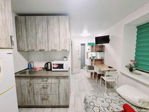 una pequeña cocina con fregadero y microondas en Сomfort24 Апартаменти на проспекті Гагаріна Мечнікова Apartment on Gagarina, en Dnipro