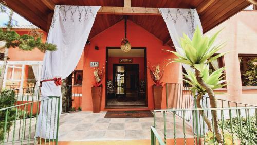 a front door of a house with a red building at Pousada Pinhão e Poesia in Canela