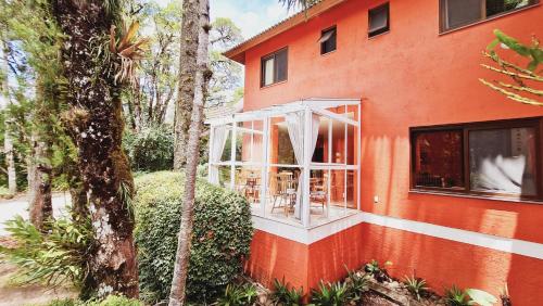 a orange house with a white window on the side of it at Pousada Pinhão e Poesia in Canela