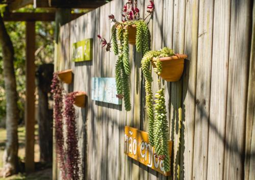 a wooden fence with plants on the side of it at Pousada Gopak in Praia do Rosa