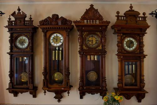 four clocks are hanging on a wall at Gasthof Dreiländereck in Schwarzenberg am Bohmerwald