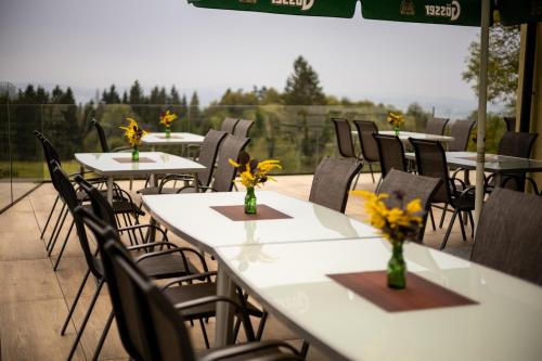 a group of tables and chairs with flowers on them at Gasthof Dreiländereck in Schwarzenberg am Bohmerwald