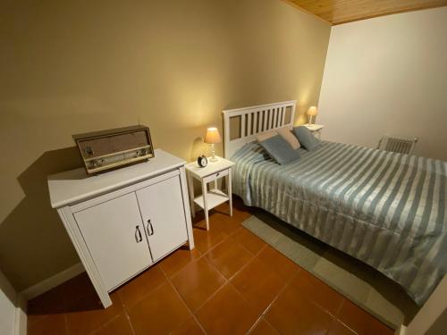 Ribeira dos Caldeirões في Achada: غرفة نوم فيها سرير وراديو