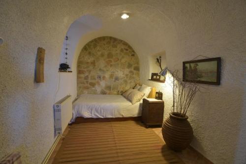 a bedroom with a bed and a stone wall at St. John Traditional House in Áyios Ioánnis