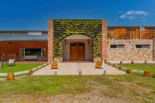 a brick building with a wooden door and a balcony at Hotel de campo Haras Los Abuelos in Sierra de los Padres