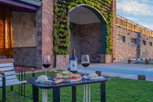 a table with a plate of food and two glasses of wine at Hotel de campo Haras Los Abuelos in Sierra de los Padres