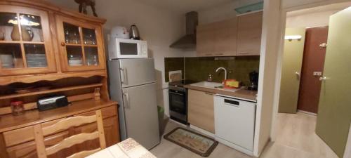 een keuken met een witte koelkast en een wastafel bij Idéal pour les vacances in Selonnet
