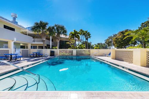 a swimming pool with blue chairs and a building at Come Stay Where the Dolphins Play! in Ruskin