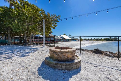 a fire pit on a beach next to the water at Come Stay Where the Dolphins Play! in Ruskin