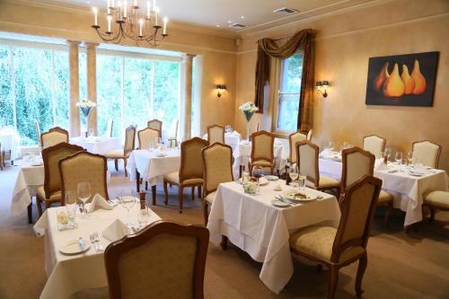 a dining room with tables and chairs with white tablecloths at Milton Park Country House Hotel & Spa in Bowral