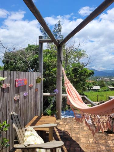 a hammock on a patio with a fence at Pousada Gopak in Praia do Rosa
