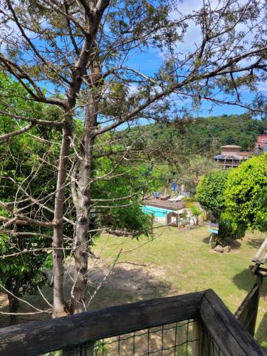a view of a yard with a tree and a pool at Pousada Gopak in Praia do Rosa