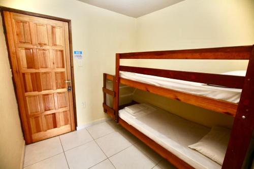 a room with two bunk beds and a door at Colonial Hotel in Ilhabela