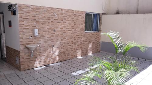 uma casa de banho com um lavatório e uma parede de tijolos em Seu Apto Praia da Costa Centro 4 Barato Não divide 2Q Completo Ar Cond Fogão Geladeira Excel Localização em Vila Velha