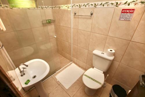 a small bathroom with a toilet and a sink at Colonial Hotel in Ilhabela