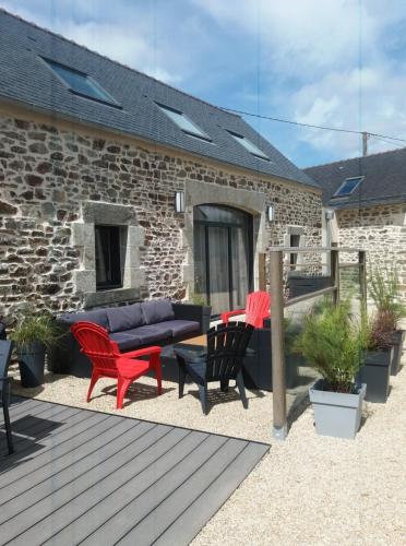 a patio with a couch and chairs on a deck at Gîte de Rosvern in Commana