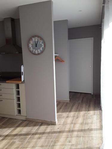 a clock on a wall next to a door at Gîte de Rosvern in Commana