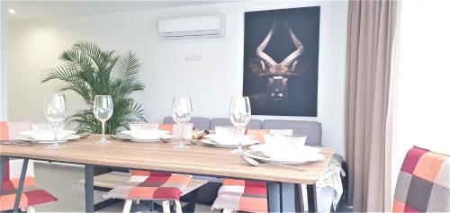 a dining room table with wine glasses and chairs at HD Mogán Canal Apartments in Puerto de Mogán