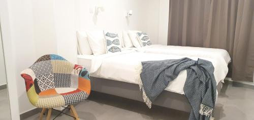 a bedroom with a bed and a chair at HD Mogán Canal Apartments in Puerto de Mogán