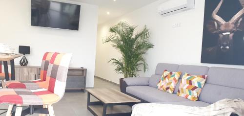 a living room with a couch and a table at HD Mogán Canal Apartments in Puerto de Mogán