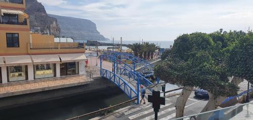 a blue bridge over a river in a city at HD Mogán Canal Apartments in Puerto de Mogán