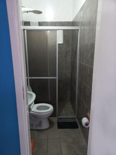a small bathroom with a toilet and a shower at Suíte Barros in Navegantes