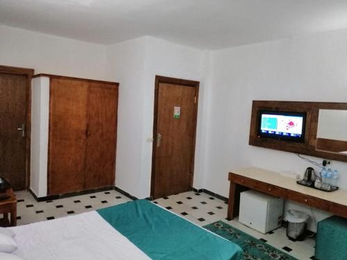 a hotel room with a television and a bed at Bella Rose Nefertiti in Hurghada