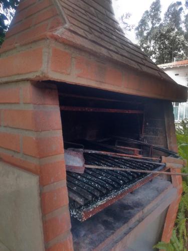 an outdoor brick oven with a roof at La Casa de Liber in Tandil